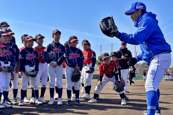 子供達にゴロの捕り方を教える湊川さん